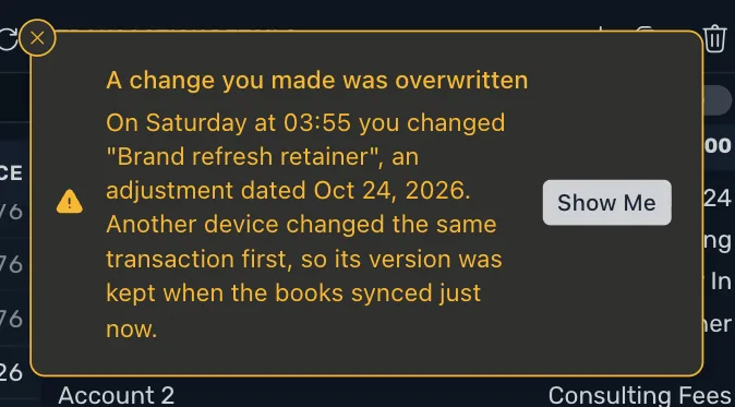 The warning A change you made was overwritten, saying that on a day and time you changed a transaction, that another device changed the same transaction first so its version was kept, and a Show Me button