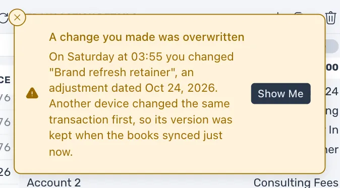 The warning A change you made was overwritten, saying that on a day and time you changed a transaction, that another device changed the same transaction first so its version was kept, and a Show Me button